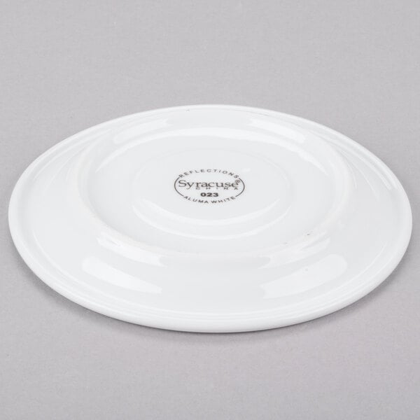 A white Libbey porcelain saucer with a small circular design in the middle.