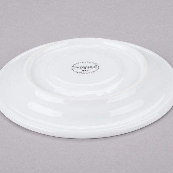 A Libbey aluma white porcelain tea saucer with a circular design on it.