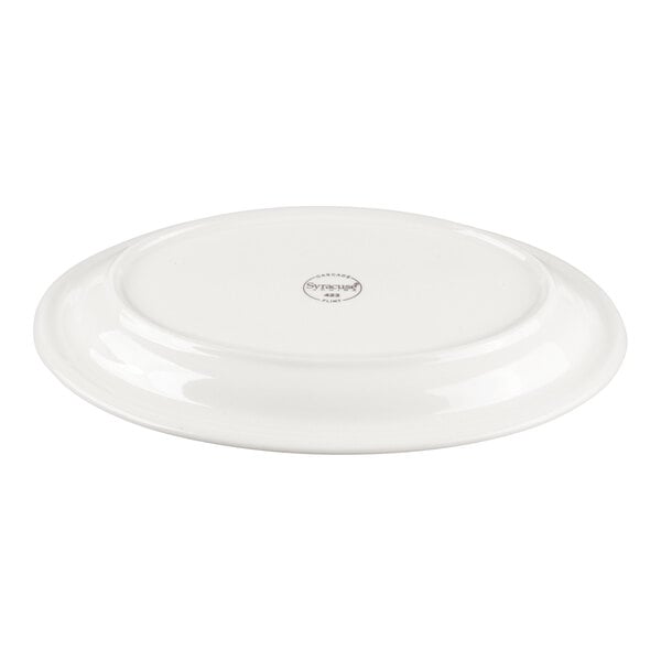 A white oval porcelain platter shown upside down with a small logo or stamp in the center.
