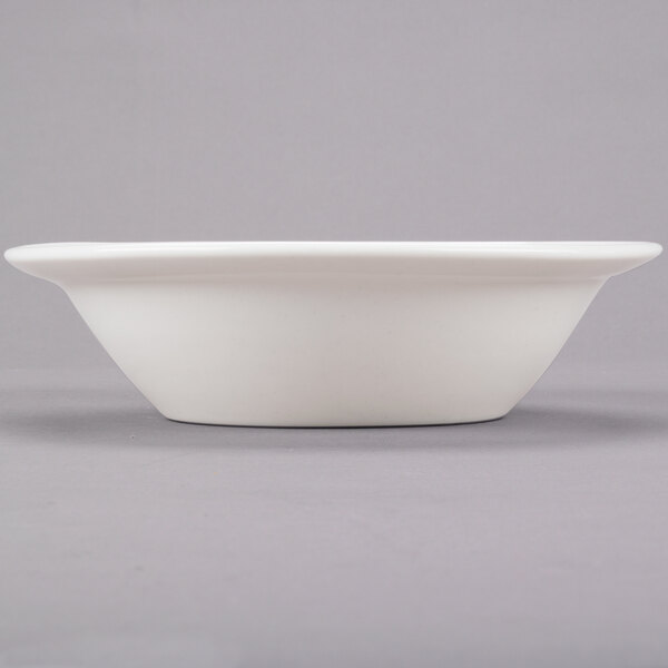 A Libbey ivory porcelain bowl with a round bottom on a gray surface.