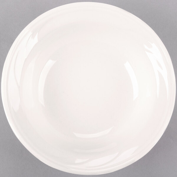 A close-up of a Libbey ivory porcelain grapefruit bowl with a rim.