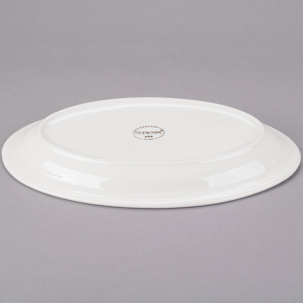 An ivory Libbey oval porcelain platter with a logo on the rim.