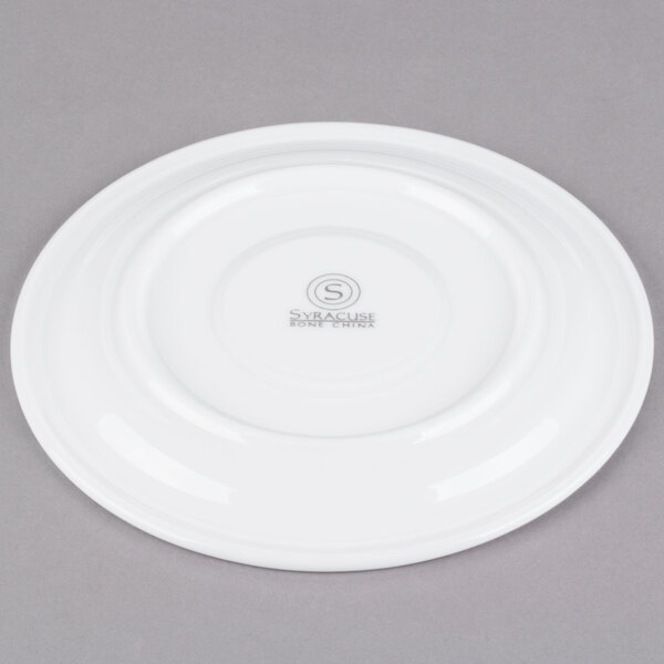 A white Syracuse China stackable saucer with a circular rim.