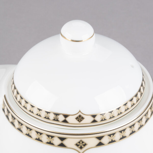 A white teapot with gold trim and lid.