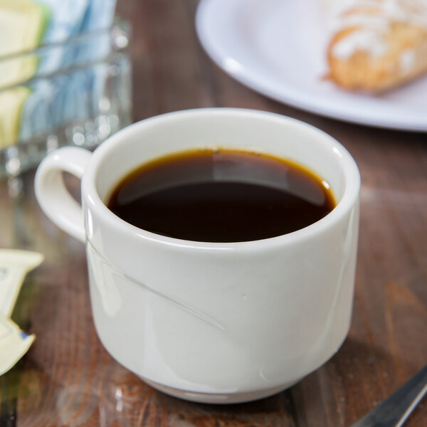 A Libbey Ivory Savoy porcelain cup of coffee on a table.