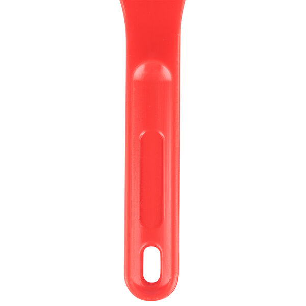 A red plastic sandwich spreader with a handle.
