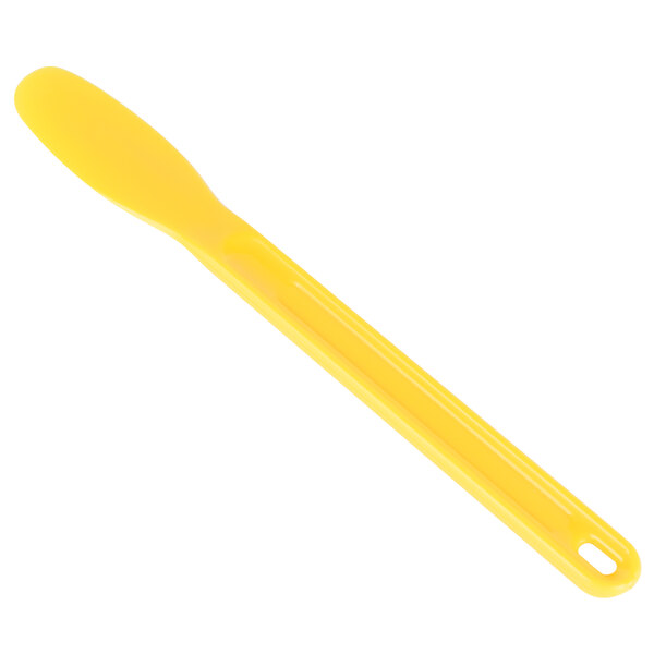 A close up of a yellow plastic sandwich spreader with a hole in the blade.