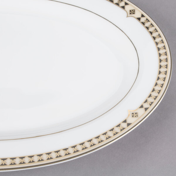 A white bone china oval platter with gold Baroque design on it.