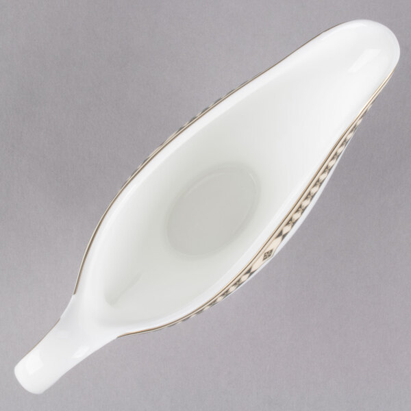 A white bone china Syracuse Baroque sauce boat with a gold plated handle.
