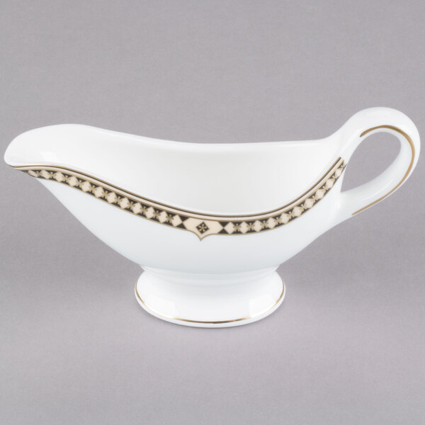 A white and gold Syracuse China sauce boat.
