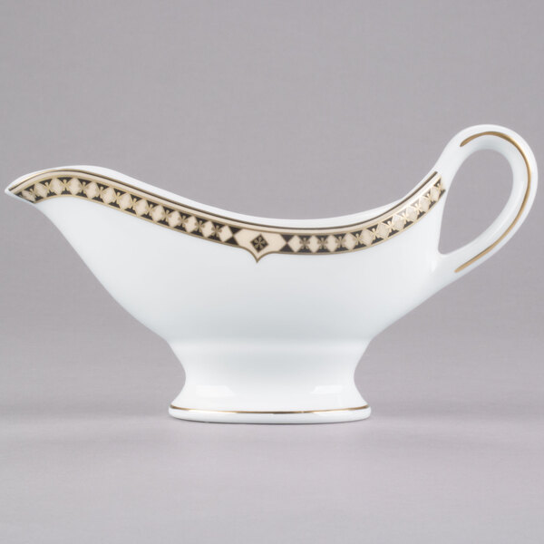 A white Syracuse China sauce boat with gold trim.