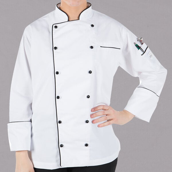 A woman wearing a white Mercer Culinary chef jacket with black piping.