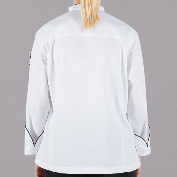 A woman wearing a white Mercer Culinary chef jacket with black piping.