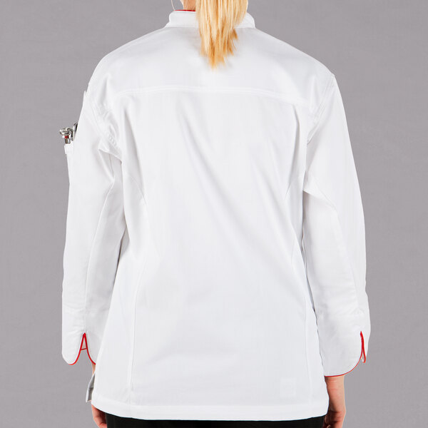 A woman wearing a white Mercer Culinary chef jacket with red trim.