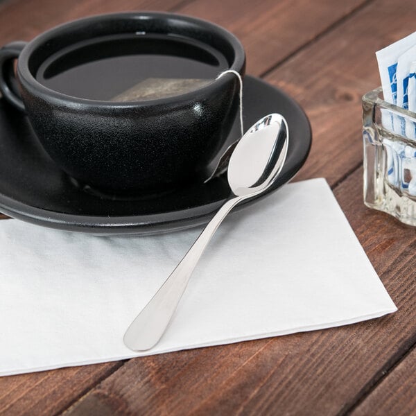 A cup of tea with a Libbey stainless steel demitasse spoon on a saucer.