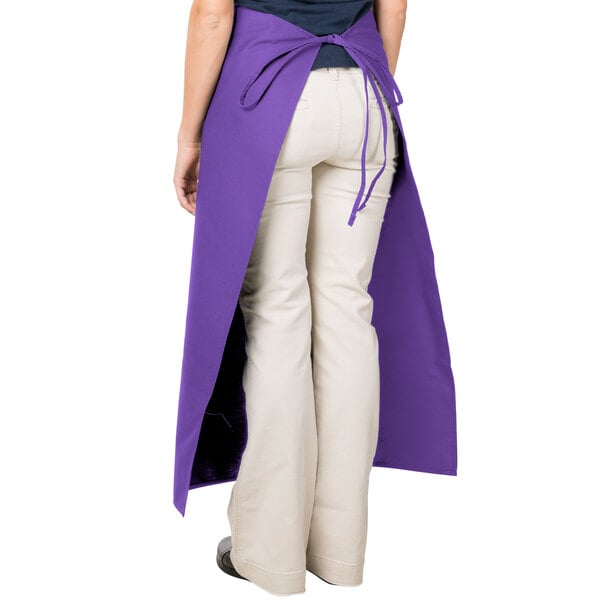 A woman wearing a purple Intedge bistro apron with two pockets.