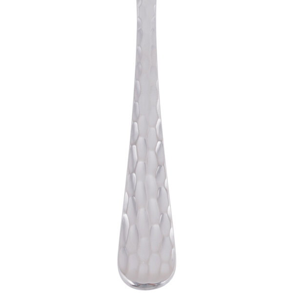 A close up of a Libbey stainless steel dessert spoon with a white handle.