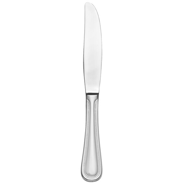 A Libbey stainless steel dessert knife with a pinched bolster and serrated blade with a silver handle and black edges on a white background.