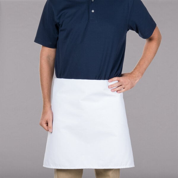 A man wearing an Intedge white waist apron at a restaurant counter.