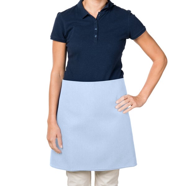 A woman wearing a light blue Intedge waist apron over a blue shirt.