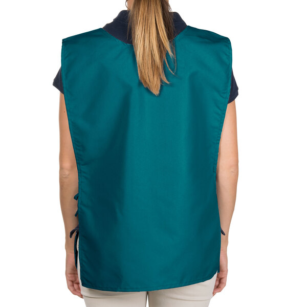 A woman wearing an Intedge teal cobbler apron over a blue vest.