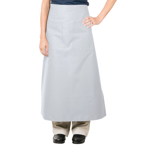 A woman wearing a gray Intedge bistro apron with 2 pockets.