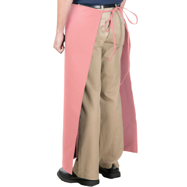 A person wearing a mauve Intedge bistro apron with two pockets.