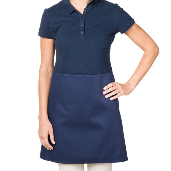 A woman wearing a navy blue Intedge waist apron.