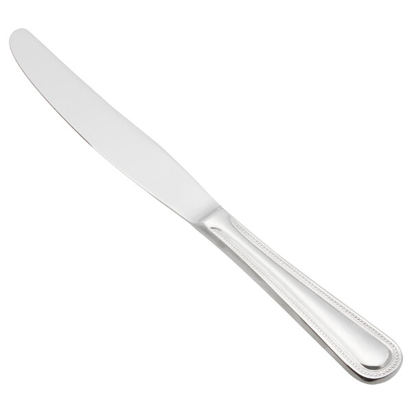 A Libbey stainless steel dinner knife with a serrated blade on a white background.