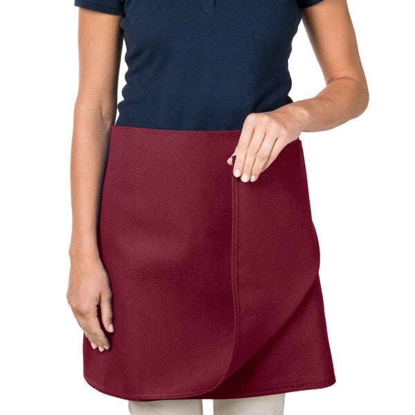 A woman wearing a burgundy Intedge waist apron.