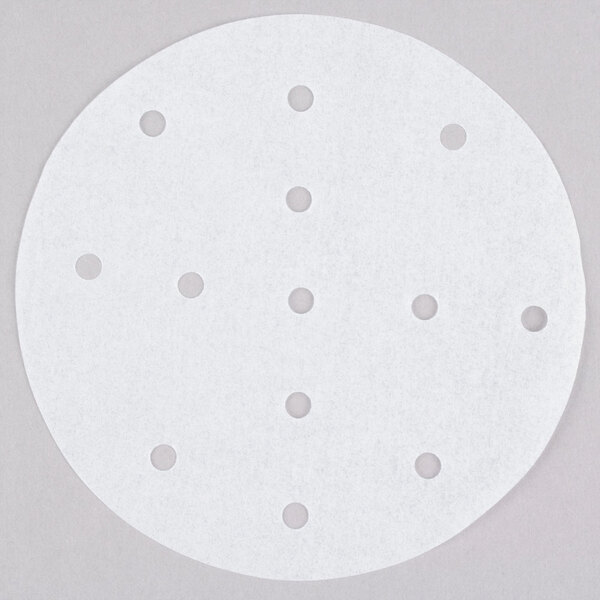 A white round patty paper with perforations in it.