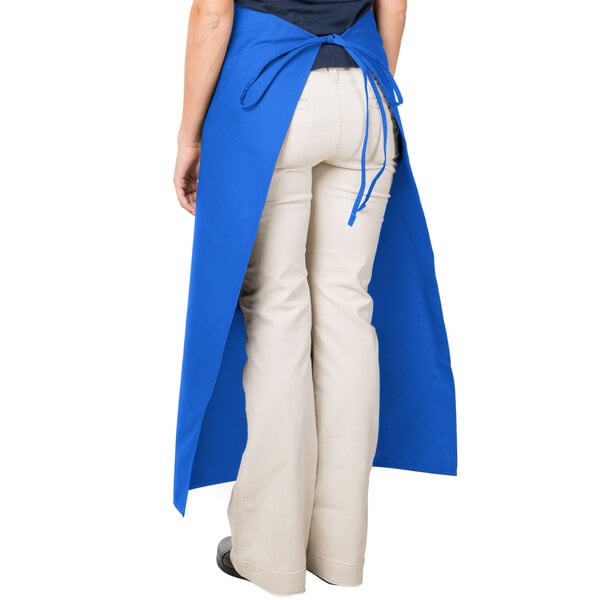 A woman wearing a blue Intedge Bistro Apron with pockets.