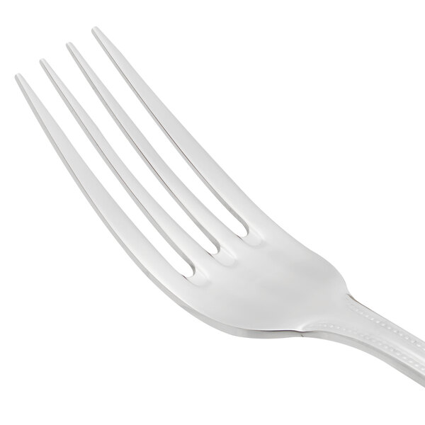A close-up of a Libbey stainless steel dinner fork with a white handle.