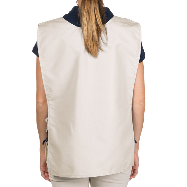 A woman wearing an ivory Intedge cobbler apron with two pockets.