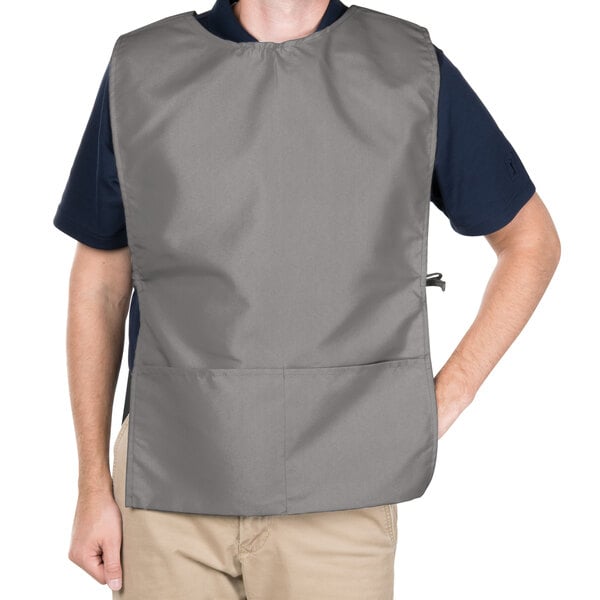 A man wearing a gray Intedge cobbler apron over a black shirt.