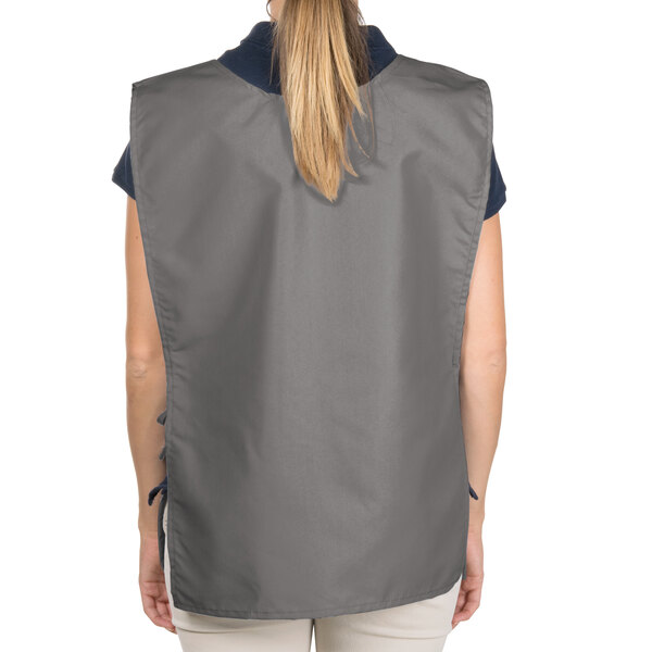 A woman wearing a gray Intedge cobbler apron with 2 pockets.