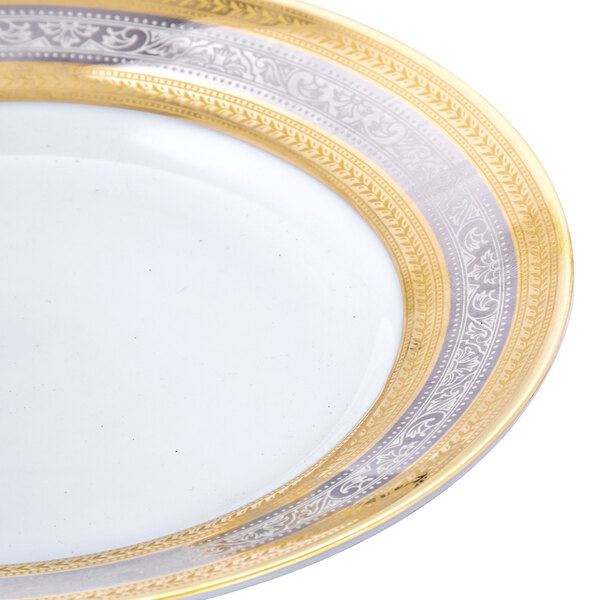 A white porcelain 10 Strawberry Street Elegance bread and butter plate with a gold rim.