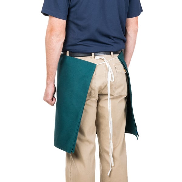 A man wearing a hunter green Intedge waist apron.