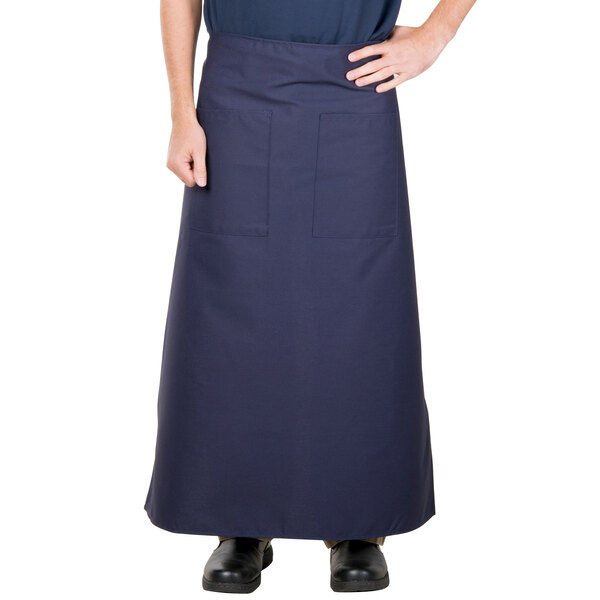 A person wearing a navy blue Intedge bistro apron with pockets.