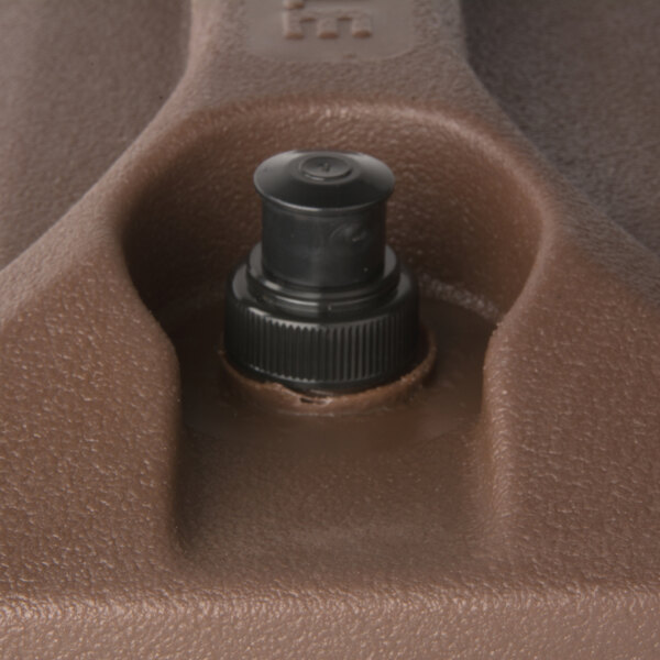 A brown plastic lid assembly for a Carlisle beverage dispenser.