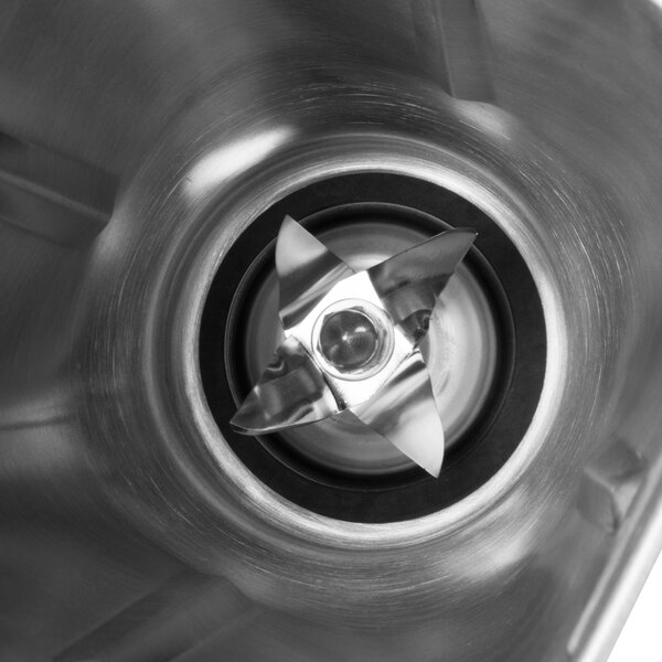 A close-up of a Waring stainless steel blender jar with a metal blade.