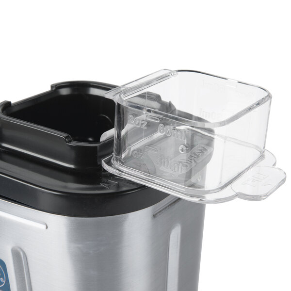 A Waring stainless steel blender jar attached to a blender.