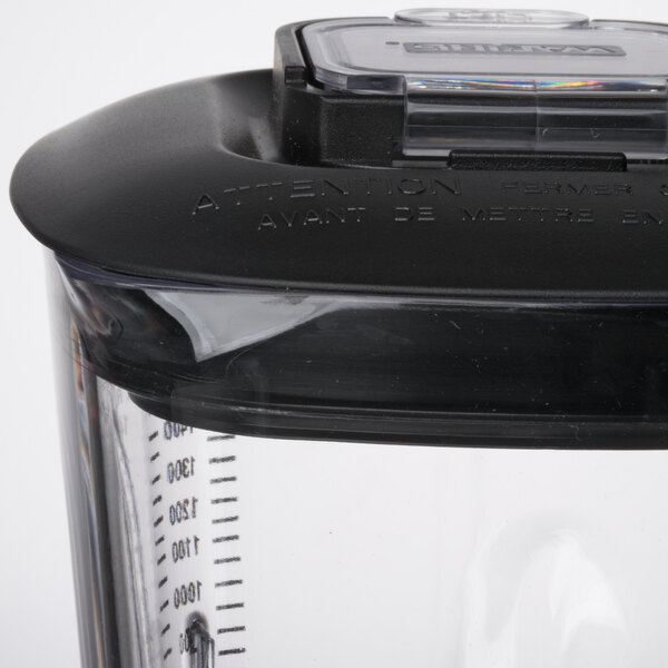 A close up of a clear Waring blender jar with a black base.