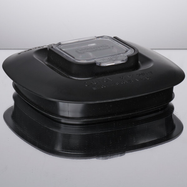 A black plastic Waring blender jar with a clear lid.