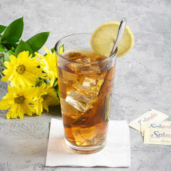 A glass of iced tea with a Libbey Geneva stainless steel iced tea spoon in it, ice, and lemon slices.