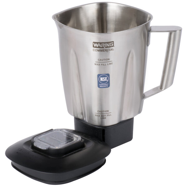 A Waring stainless steel blender jar with a black lid on a blender.