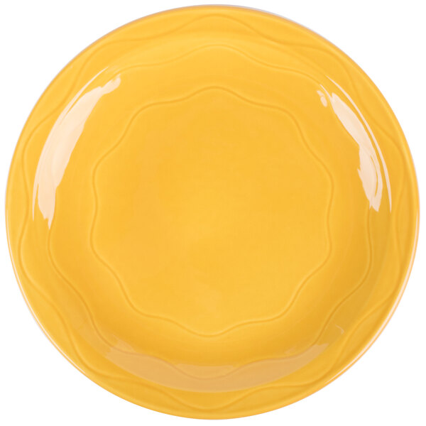 A Libbey Cantina Saffron porcelain plate with a wavy rim.