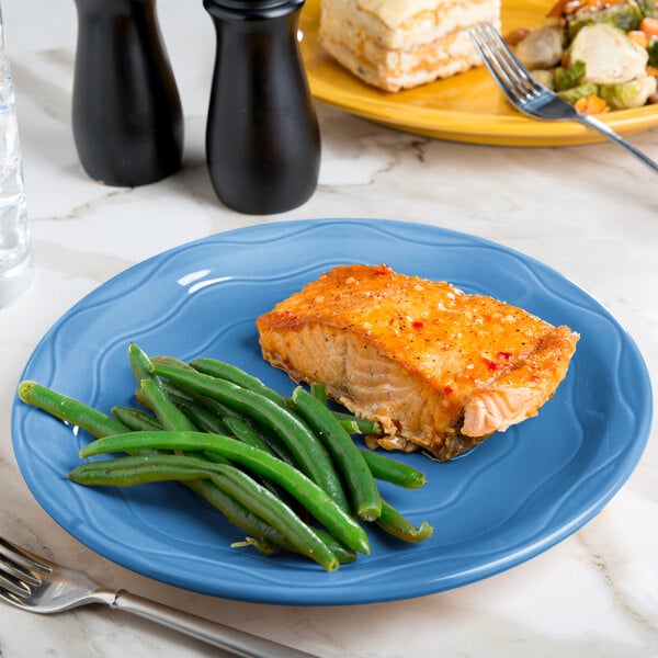 A Libbey blueberry carved porcelain plate with a piece of meat and green beans on it.