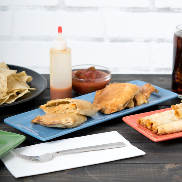 A Libbey blueberry rectangular porcelain tray with food on a table.