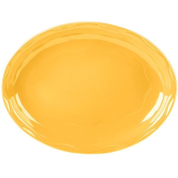 A yellow oval Libbey Cantina porcelain platter with a wavy edge.
